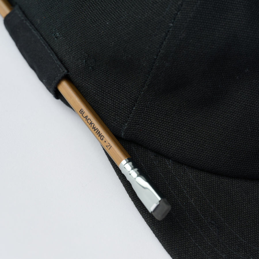 Black cap with a Blackwing Volume 21 pencil in the side loop